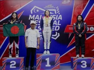 Bangladeshi racer Kashfia Arfa holds the national flag after securing second place in the Karting Slalom Ladies category at the Malaysia Festival of Speed 2026, with the Viqarunnisa Noon School & College logo featured alongside her.